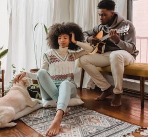 black couple with guitar near dog