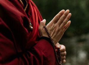 hands holding a brown prayer beads