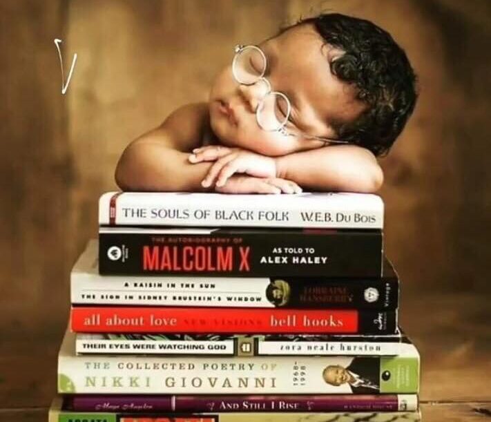 stack of books with child sleeping