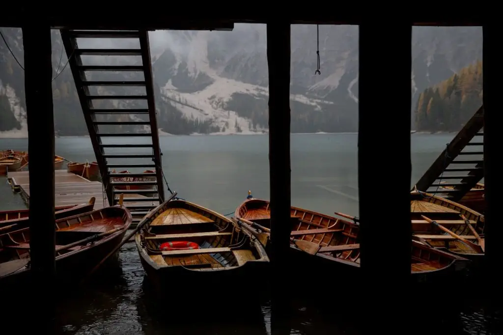 wooden boats moored under pier on lake