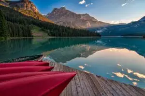 red canoes on sea dock near calm body of water