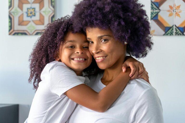 a happy girl hugging her mother