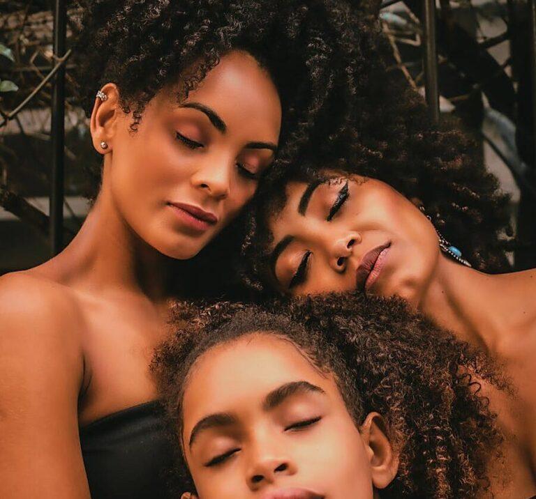 black women and girl with closed eyes in street