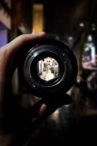 person holding black camera lens
